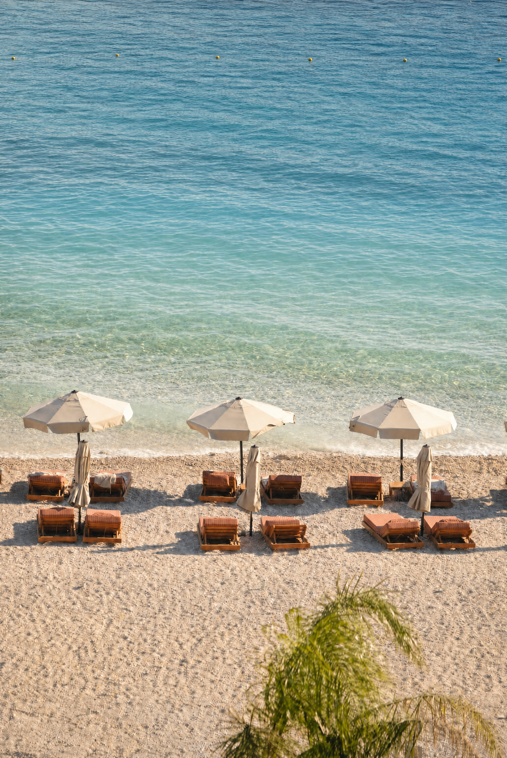 Chaonian Hotel — the pebble beach below, set with parasols and loungers