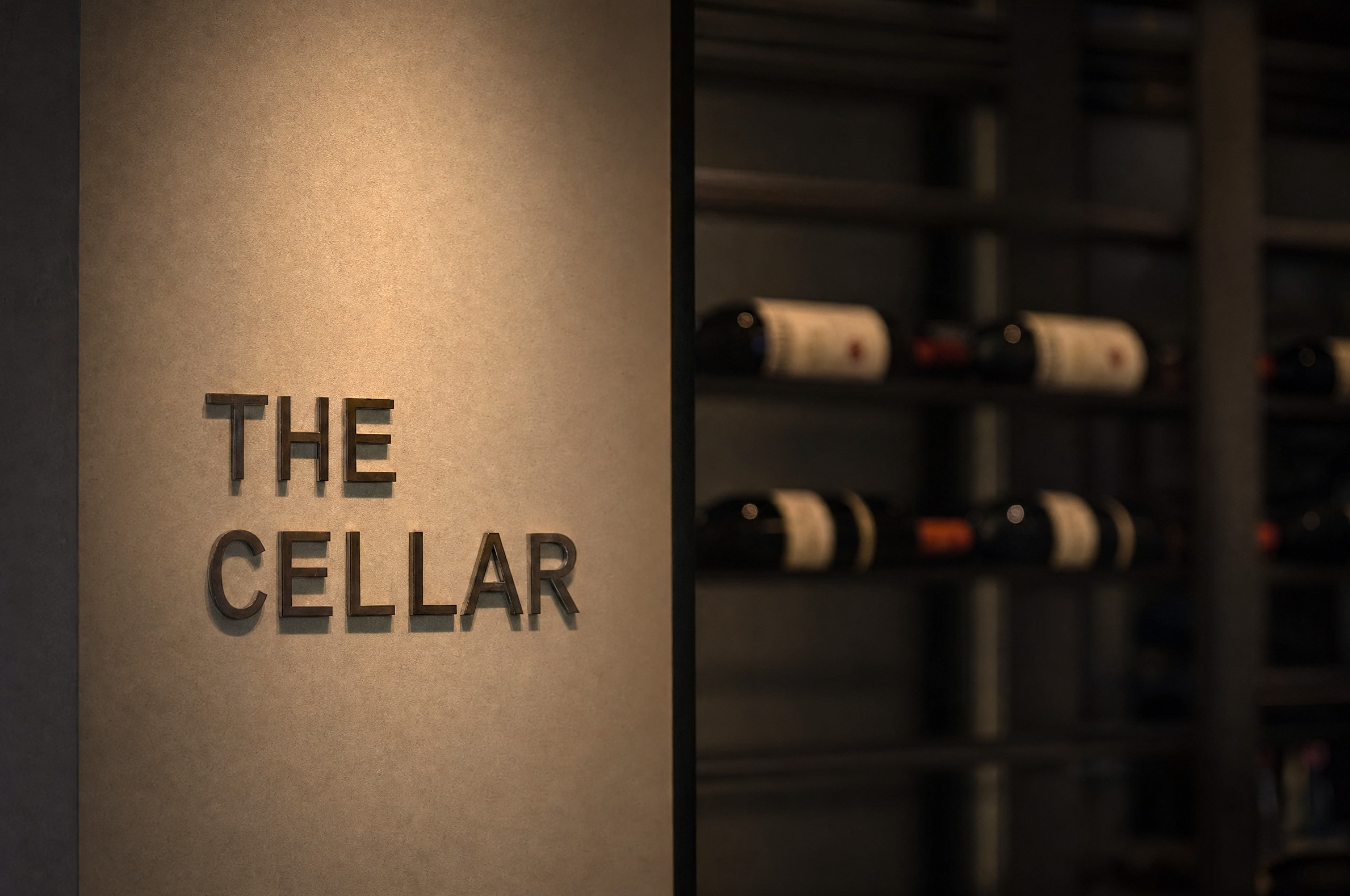 The Cellar — shkrimi prej bronzi mbi raftet e verërave